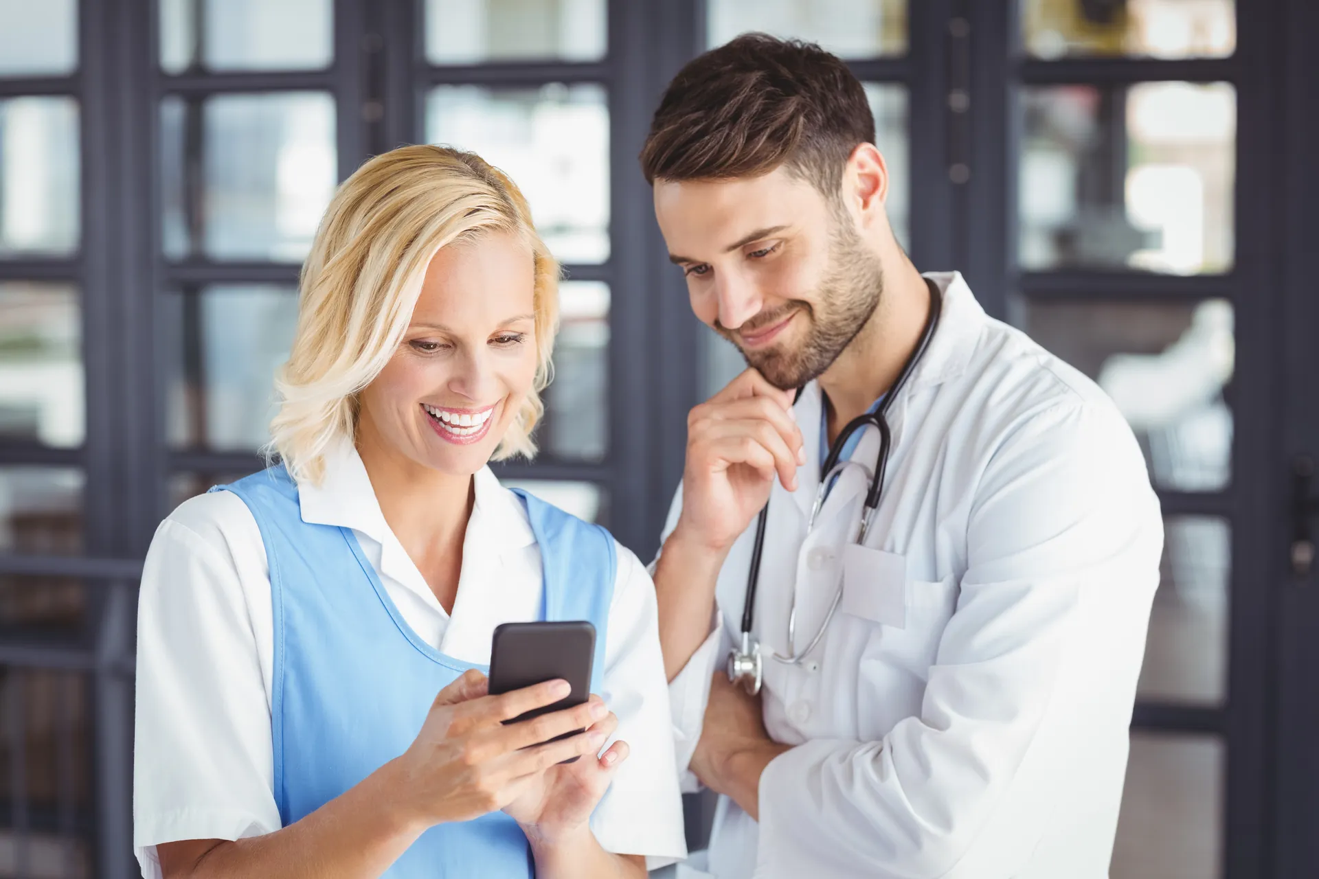 Two clinicians reviewing information on a smartphone