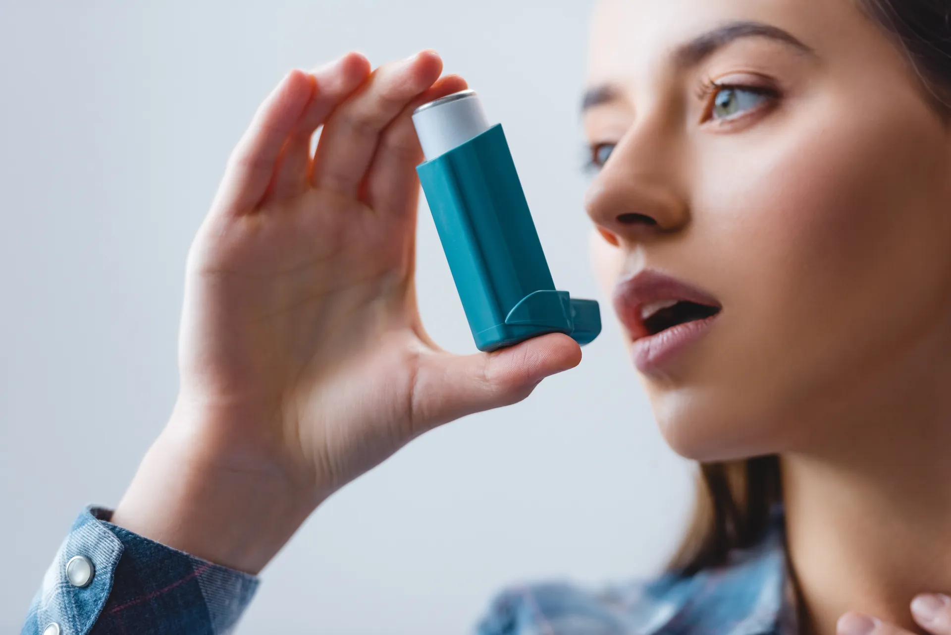 Woman holding a pressurized metered-dose inhaler