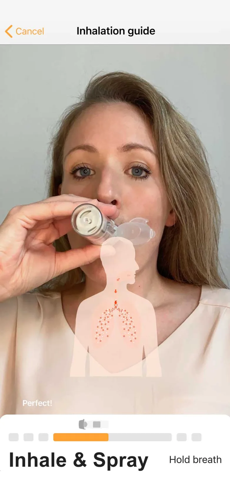 Kata inhalation guide: a patient inhales from her inhaler while the app coaches the "Inhale & Spray" step